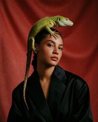 a woman with a lizard on her head