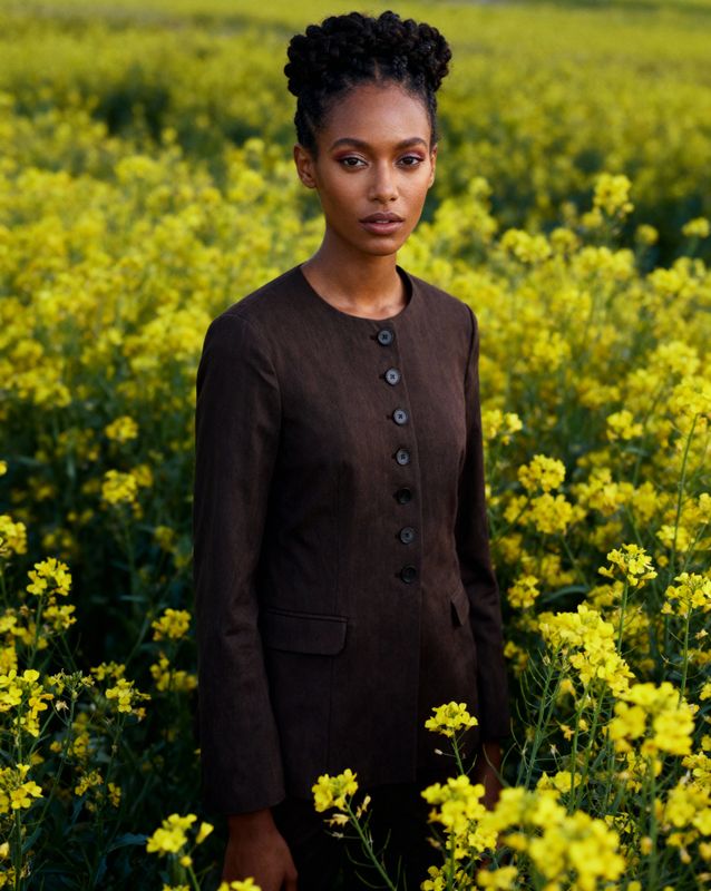 a woman standing in a field of yellow flowers
