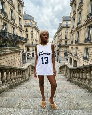 a woman in a white jersey is standing on some steps