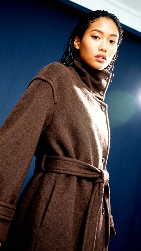 a woman standing in front of a blue wall