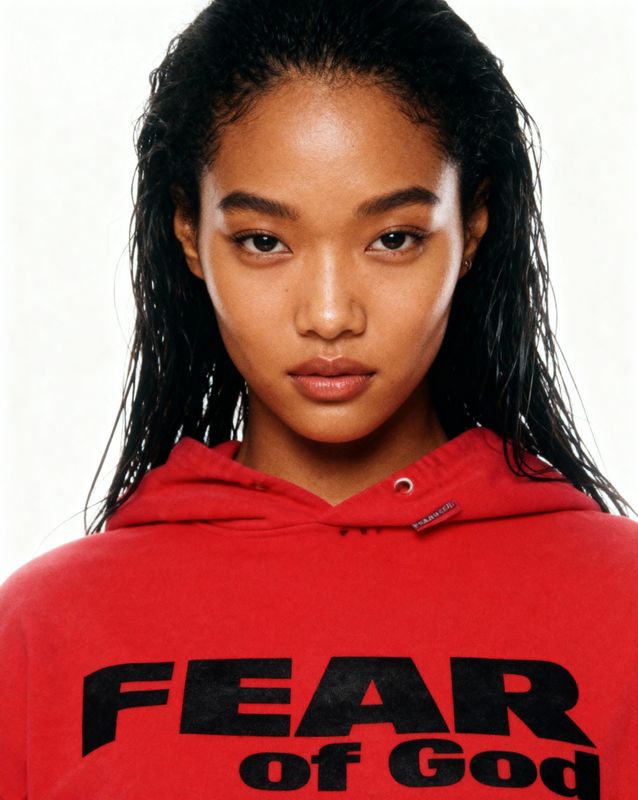 a woman wearing a red hoodie with the words fear of god on it