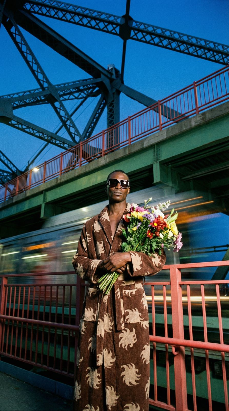 a man in a robe holding a bouquet of flowers