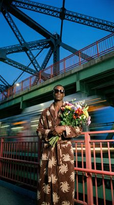 a man in a robe holding a bouquet of flowers