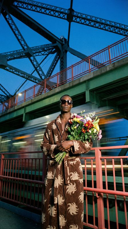 a man in a robe holding a bouquet of flowers