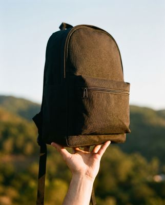 a person holding a backpack up to their face
