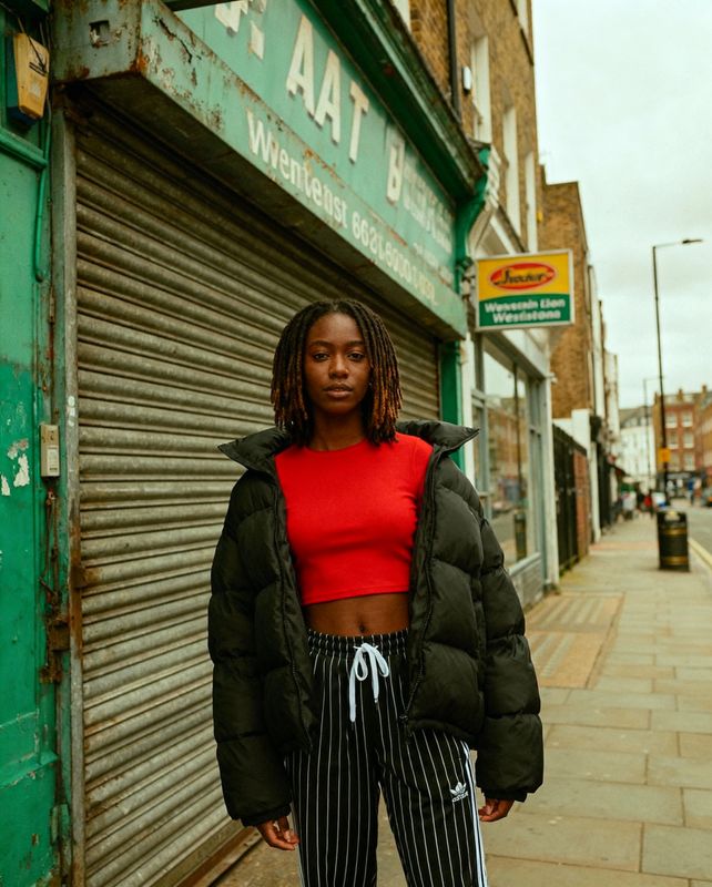 a woman standing on a sidewalk in front of a store