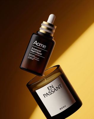 a bottle of acne against a yellow background