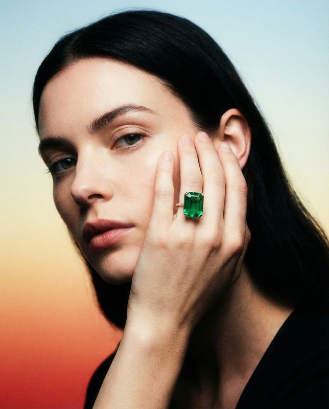 a woman with a green ring on her finger