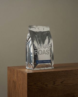 a bag of coffee sitting on top of a wooden table