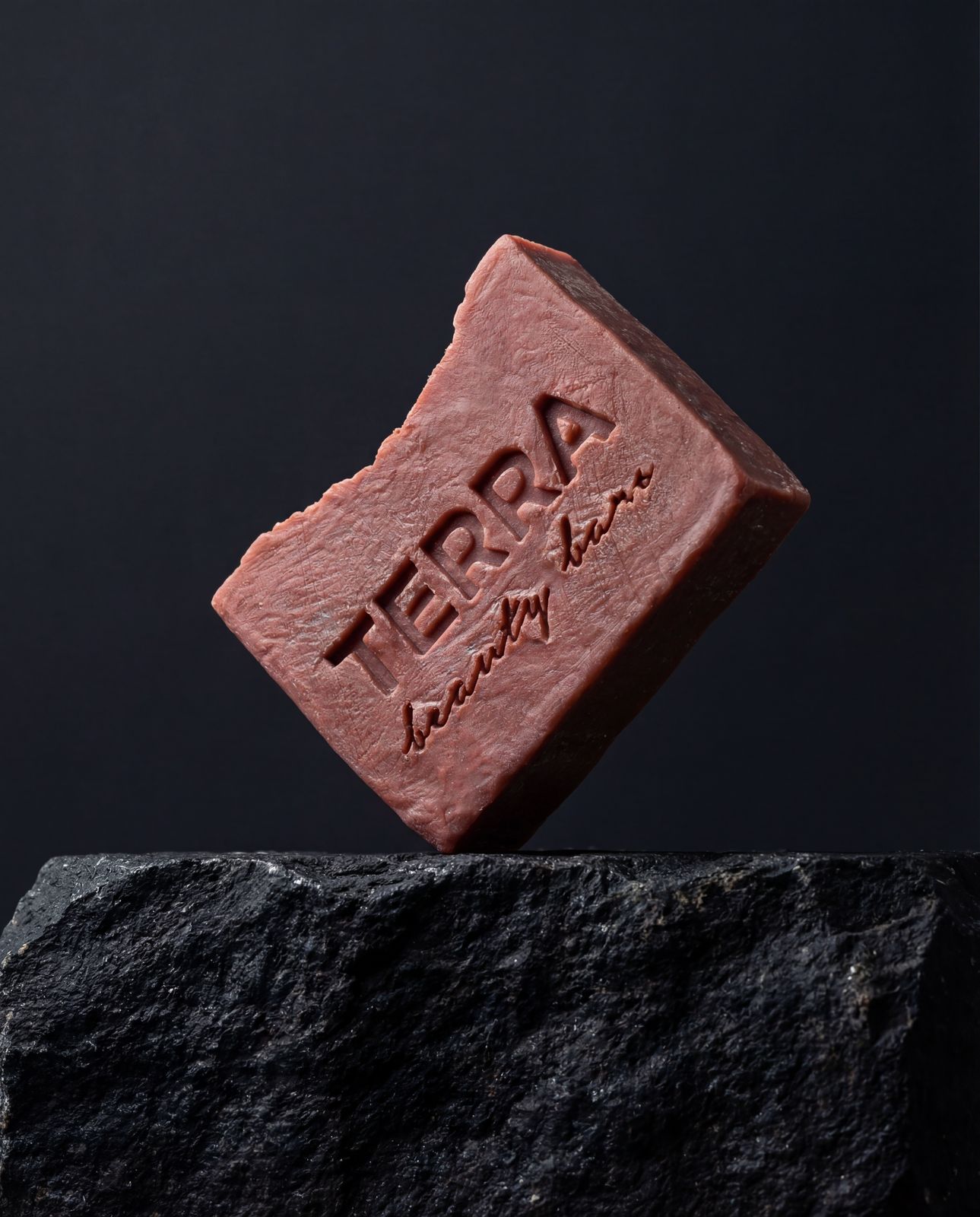 a piece of red soap sitting on top of a rock