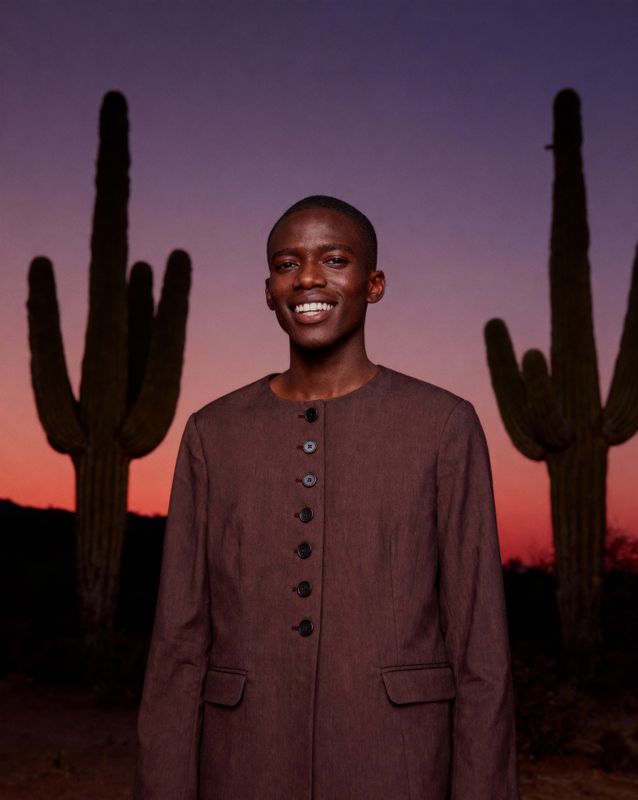 a man standing in front of a cactus