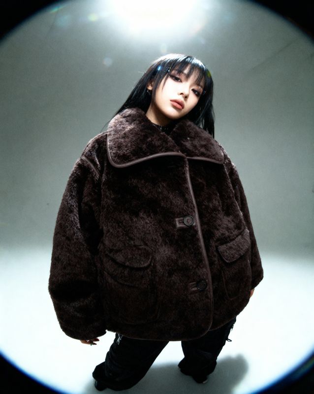a woman standing in front of a round mirror