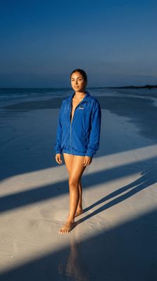 a woman standing on a beach next to the ocean