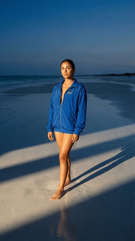 a woman standing on a beach next to the ocean