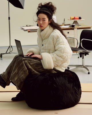 a woman sitting on top of a black dog