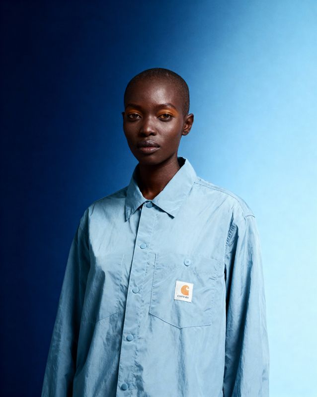 a man in a blue shirt is posing for a picture