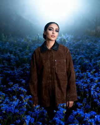a woman standing in a field of blue flowers