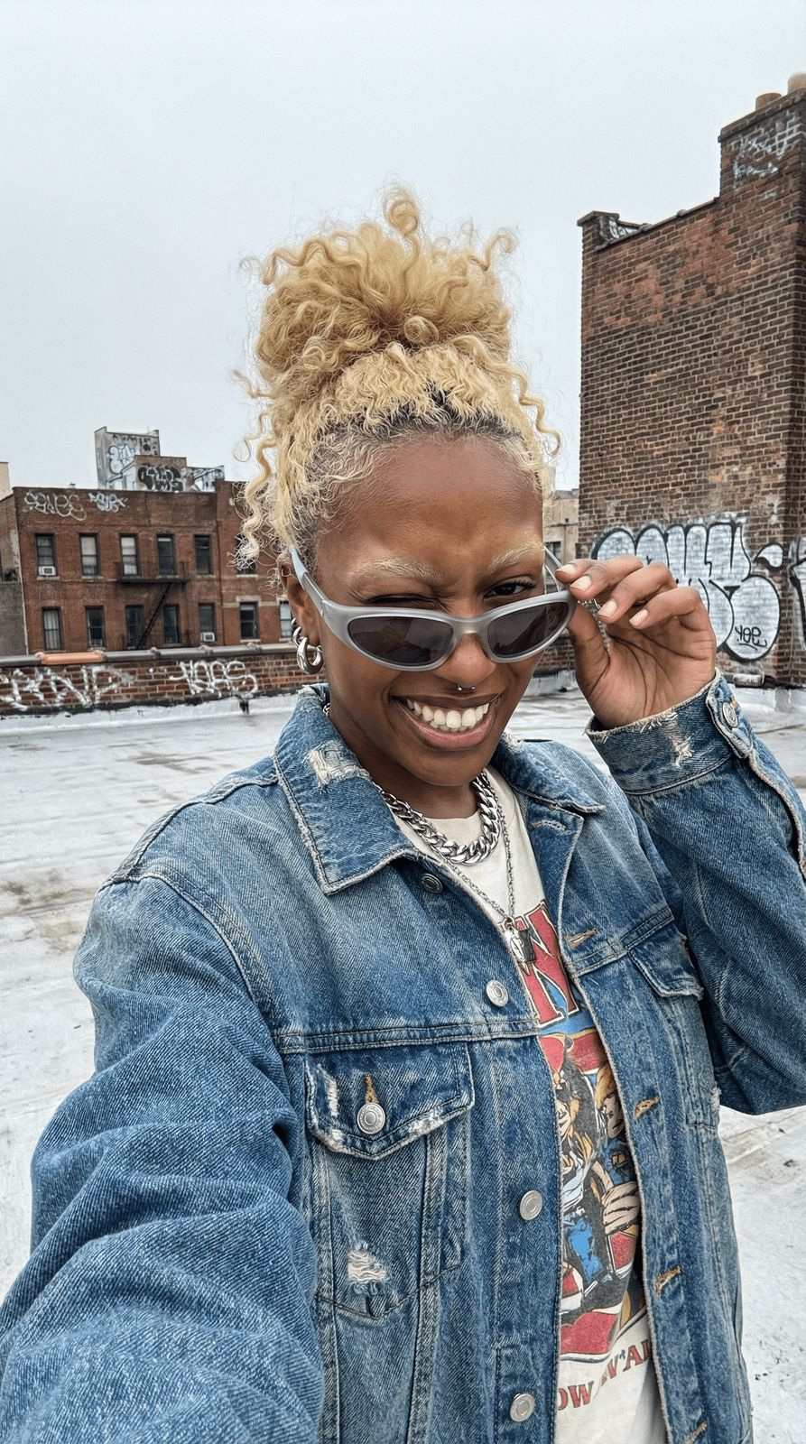 a woman wearing a jean jacket and sunglasses