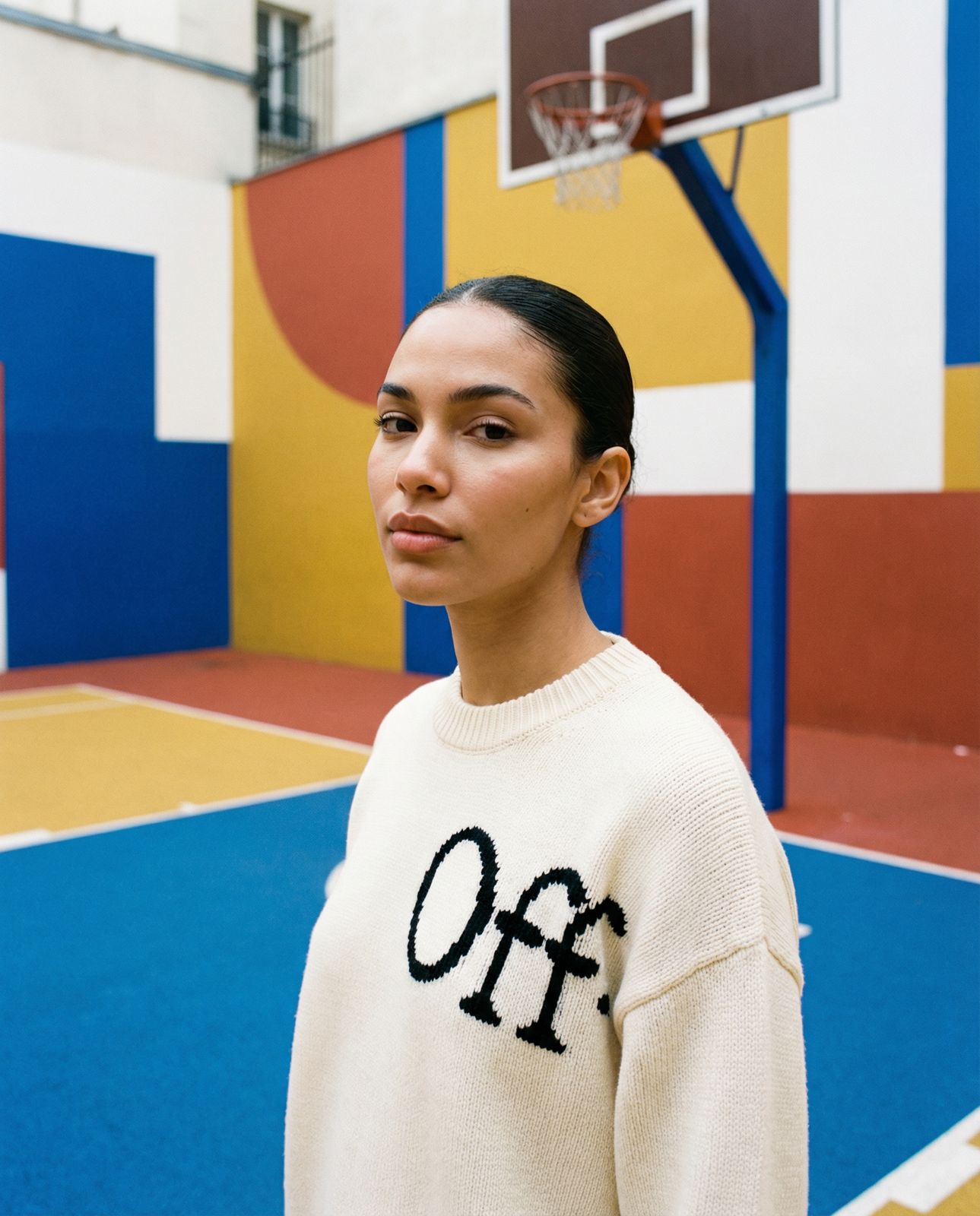 a woman standing in front of a basketball hoop