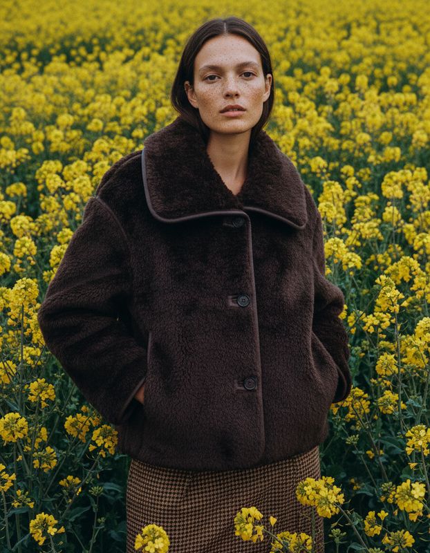 a woman standing in a field of yellow flowers