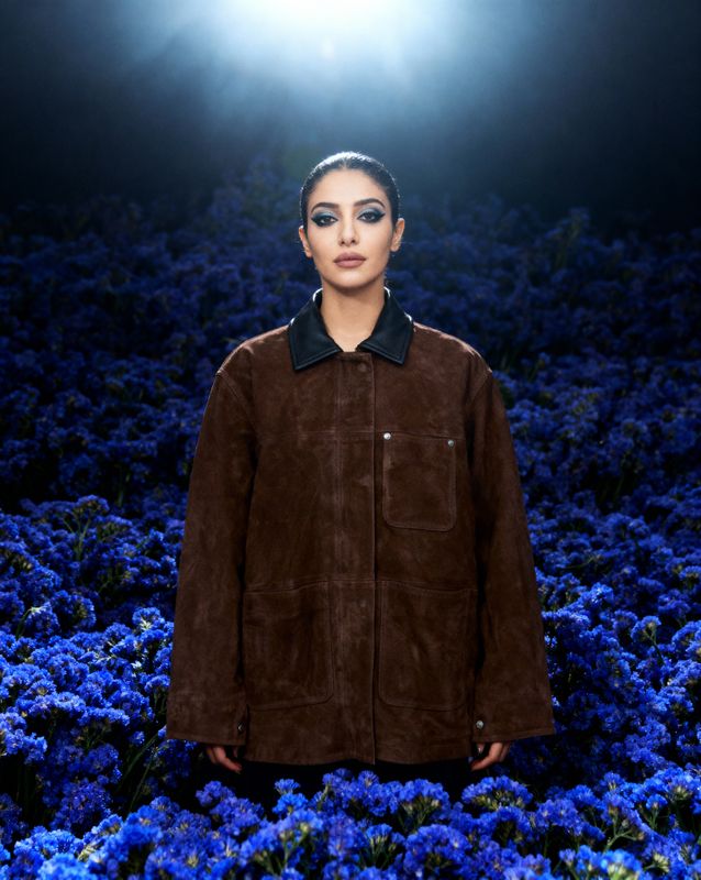 a woman standing in a field of blue flowers