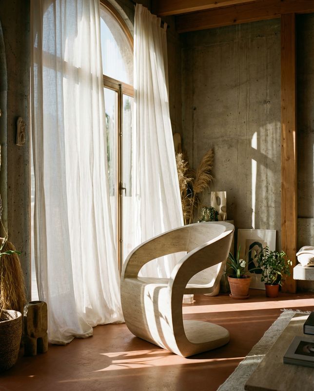 a living room with a large window and a chair