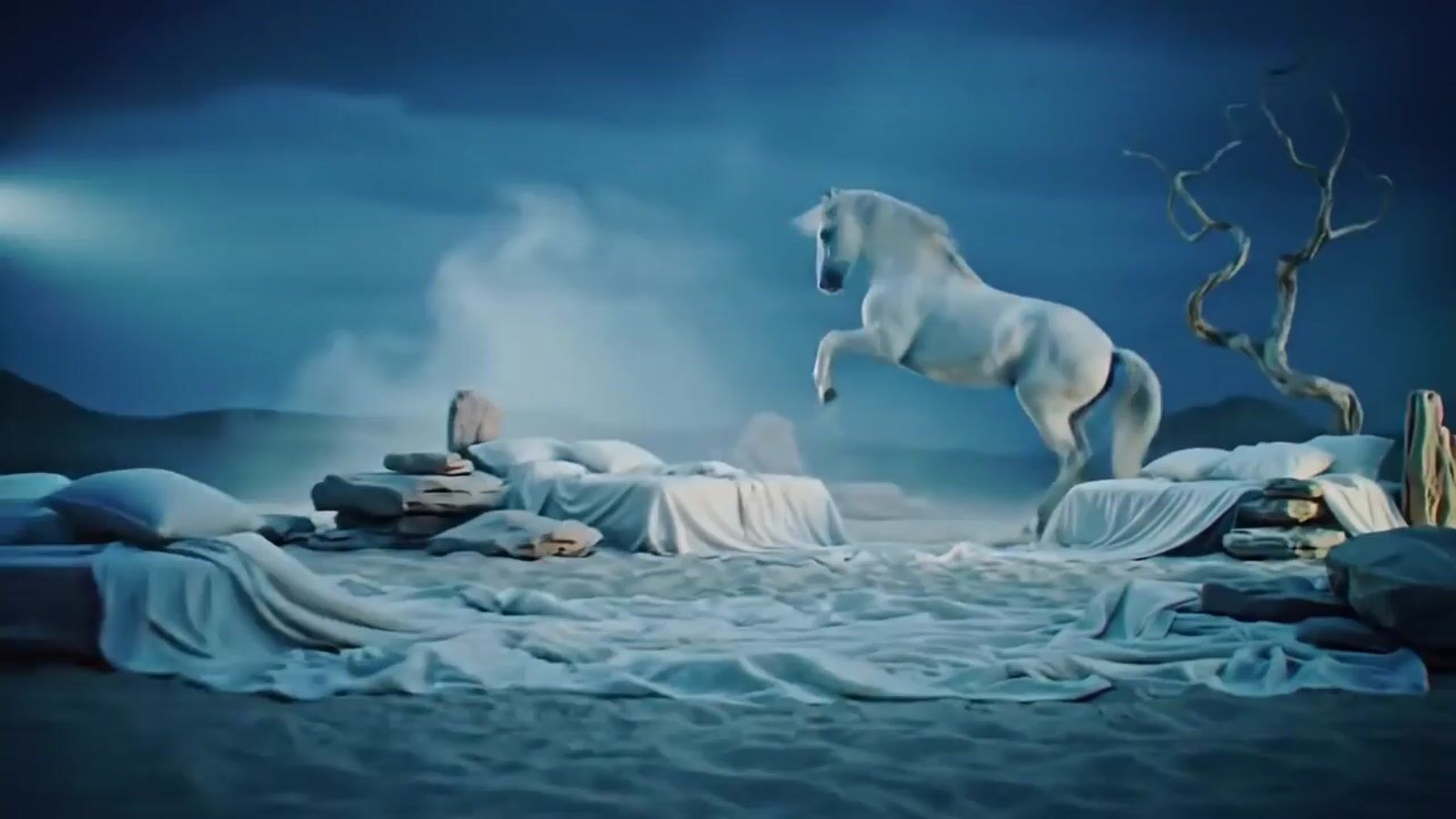 a white horse standing on top of a bed covered in blankets