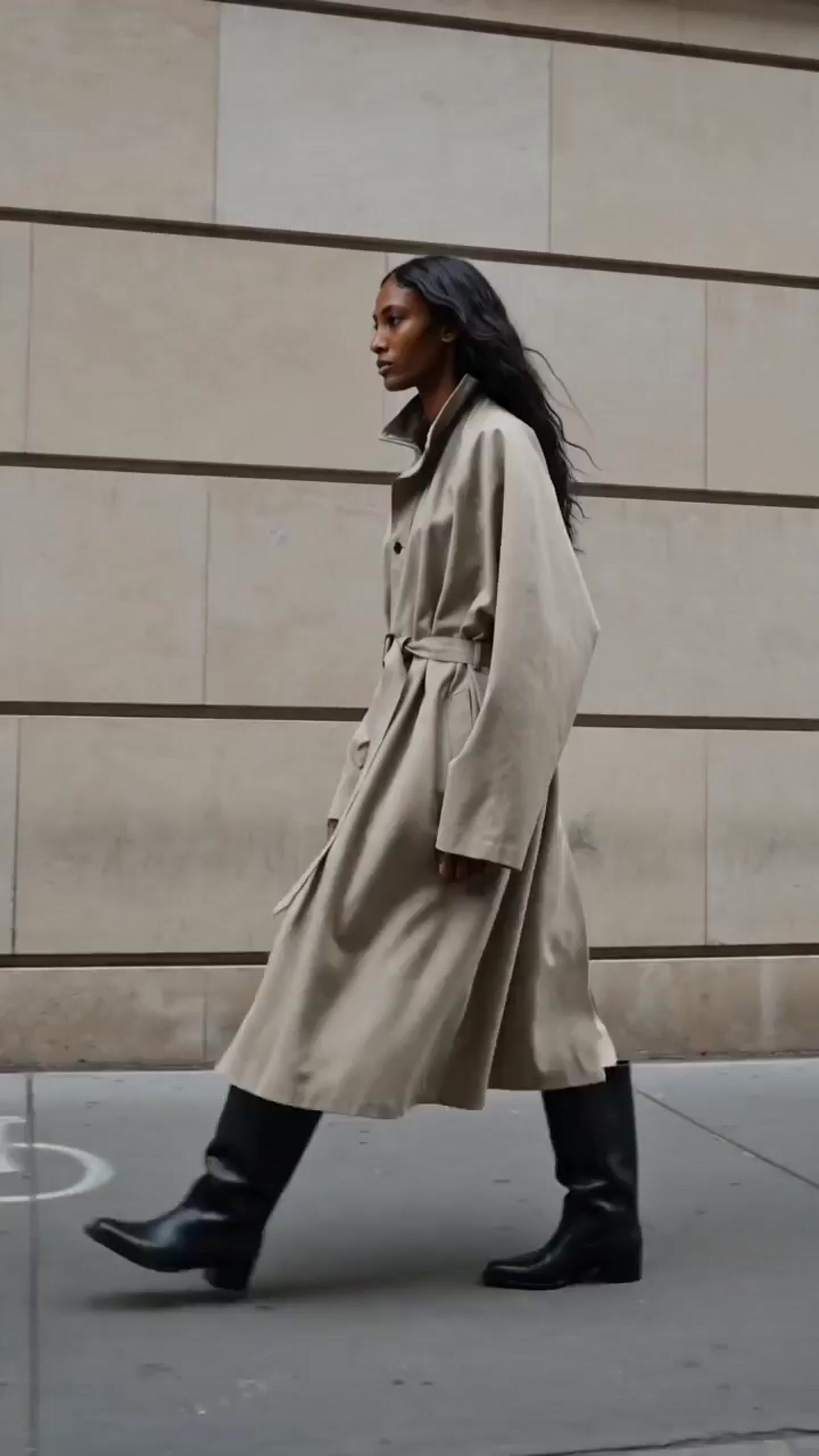 a woman walking down the street in a trench coat