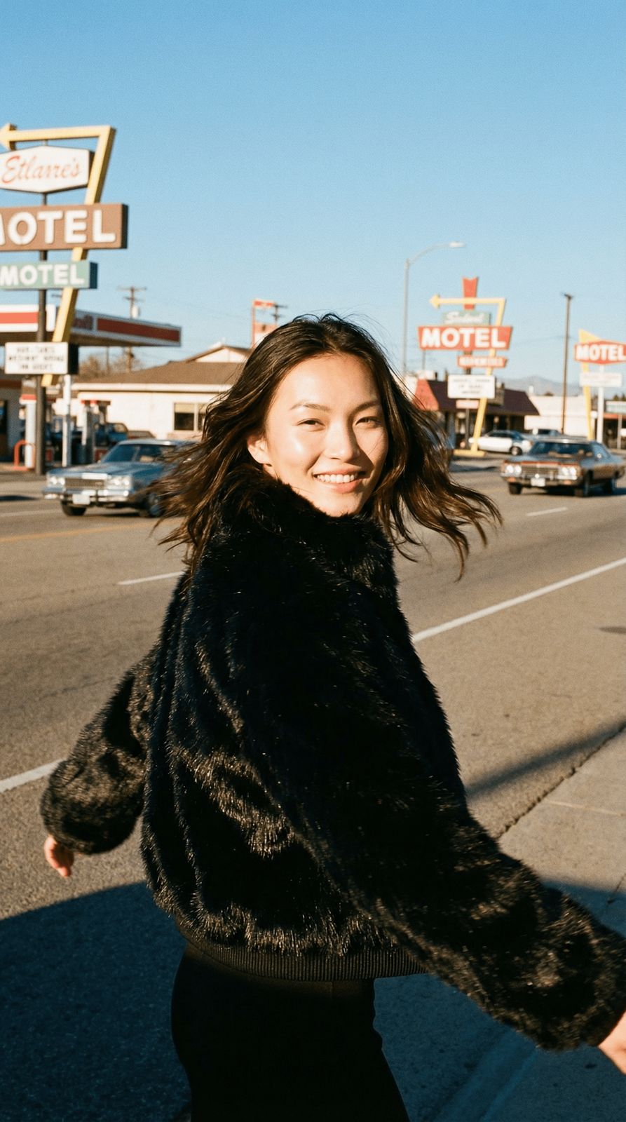 a woman walking down a street next to a motel