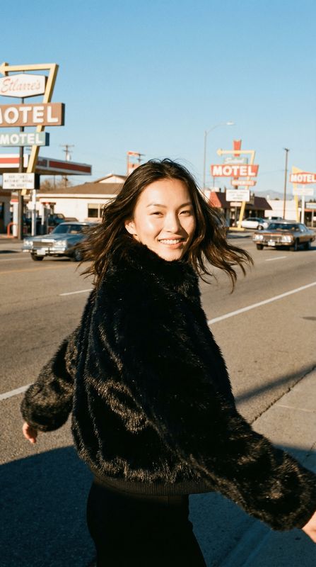 a woman walking down a street next to a motel