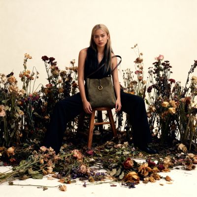 a woman sitting on a chair surrounded by flowers