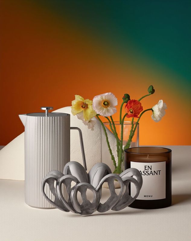 a vase with flowers and a candle on a table