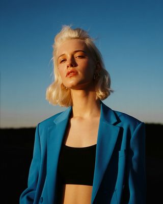 a woman with blonde hair wearing a blue jacket
