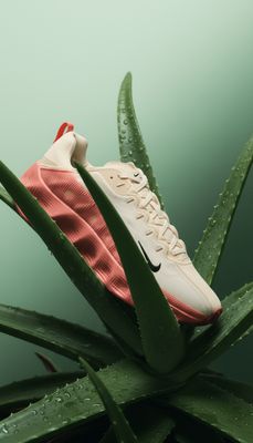 a pair of nike sneakers on top of a plant