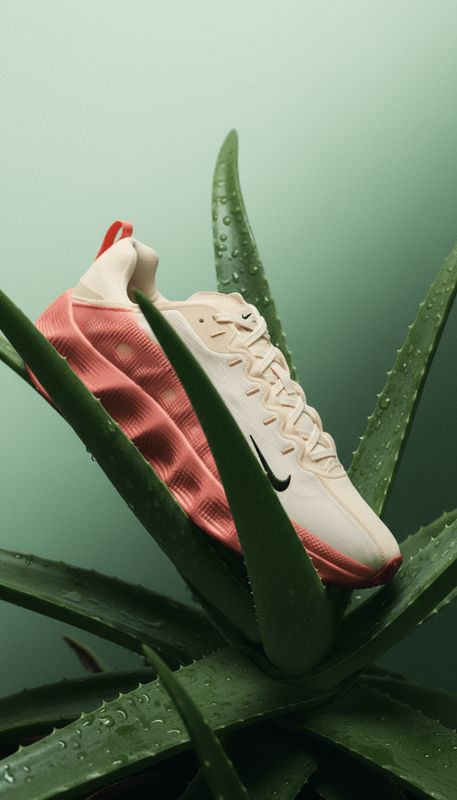 a pair of nike sneakers on top of a plant