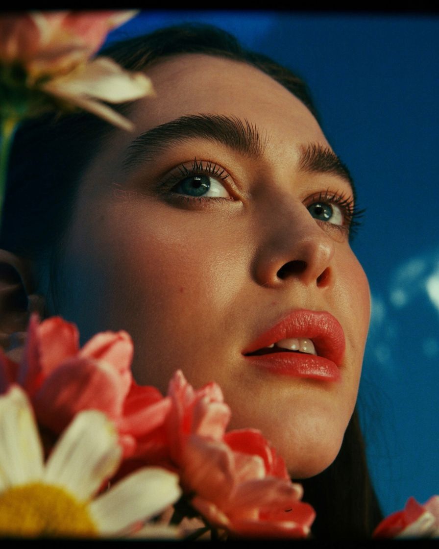 a close up of a woman with flowers in her hair