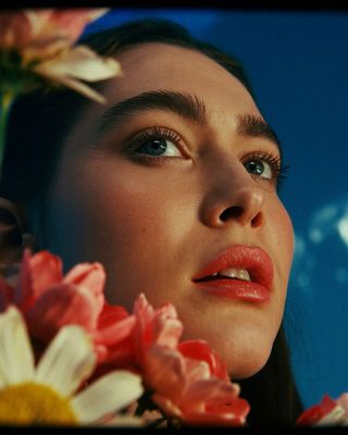 a close up of a woman with flowers in her hair