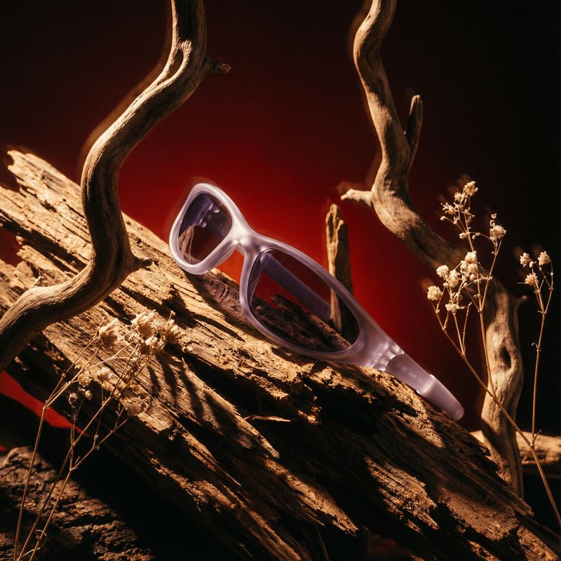 a pair of sunglasses sitting on top of a wooden log