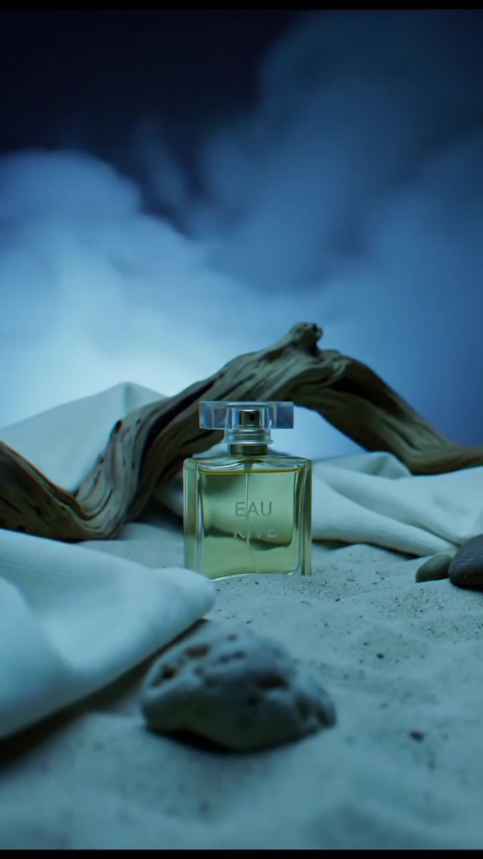 a bottle of perfume sitting on top of a bed