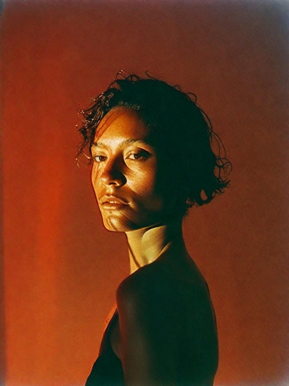 a woman is posing for a picture with a red background