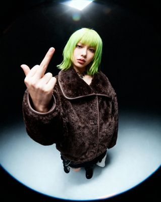 a woman with green hair making a peace sign