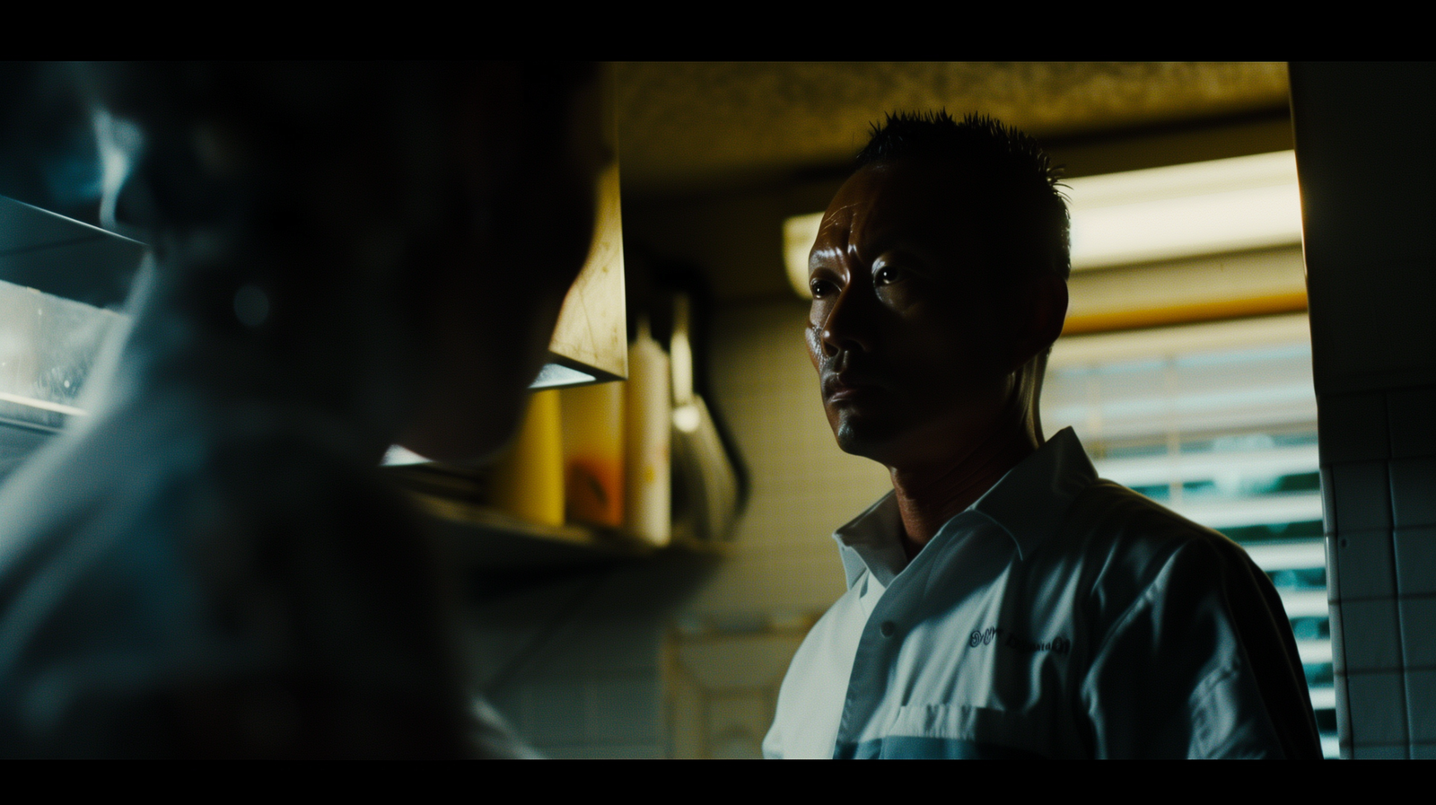 a man standing in a kitchen next to a window