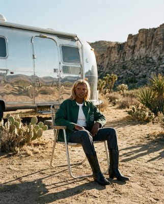 a woman sitting in a chair in front of a trailer