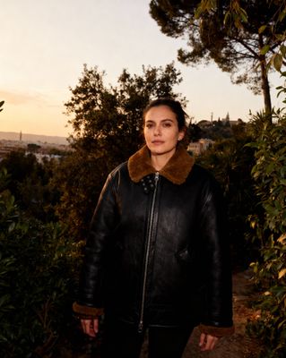 a woman wearing a black leather jacket and a fur collar