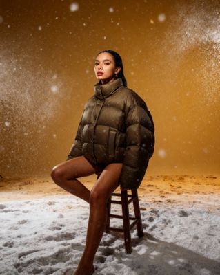 a woman sitting on a stool in the snow