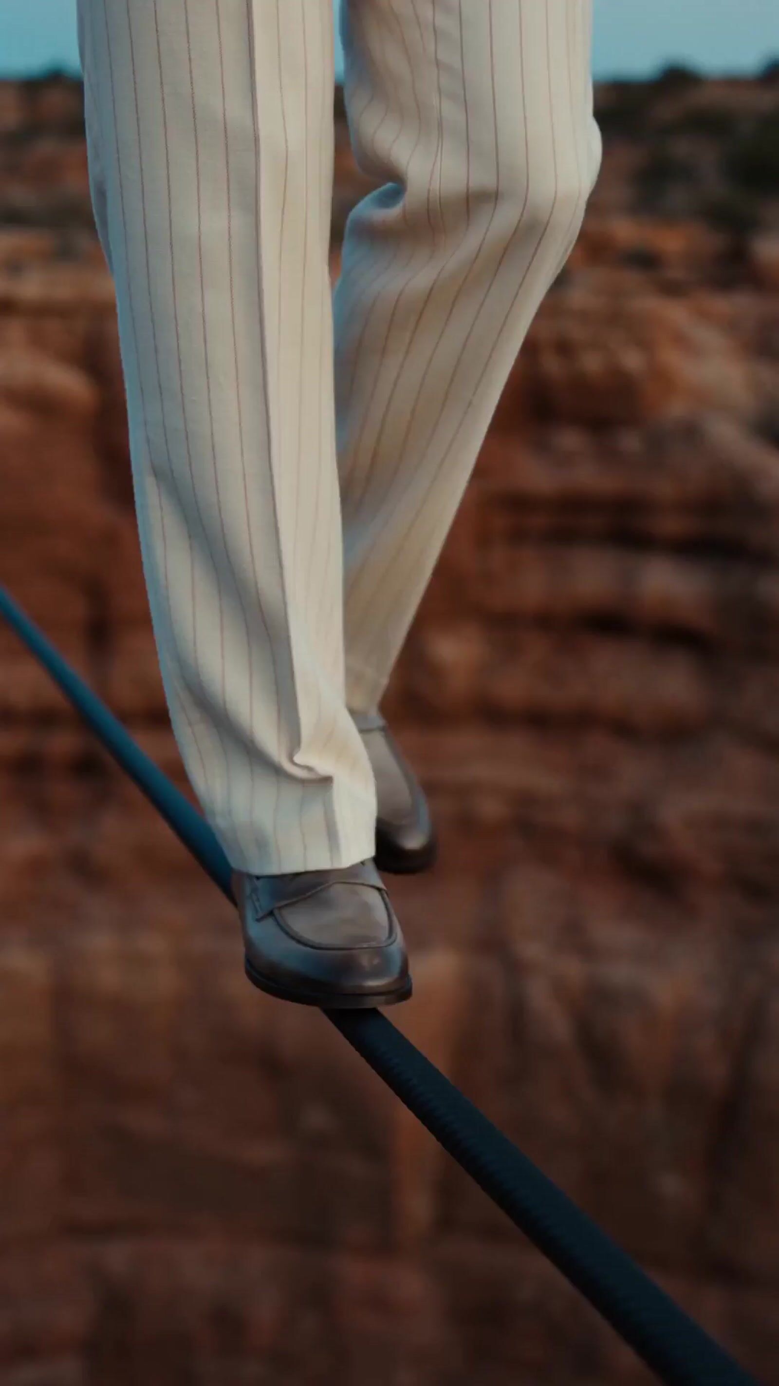 a person walking on a tight rope in a desert