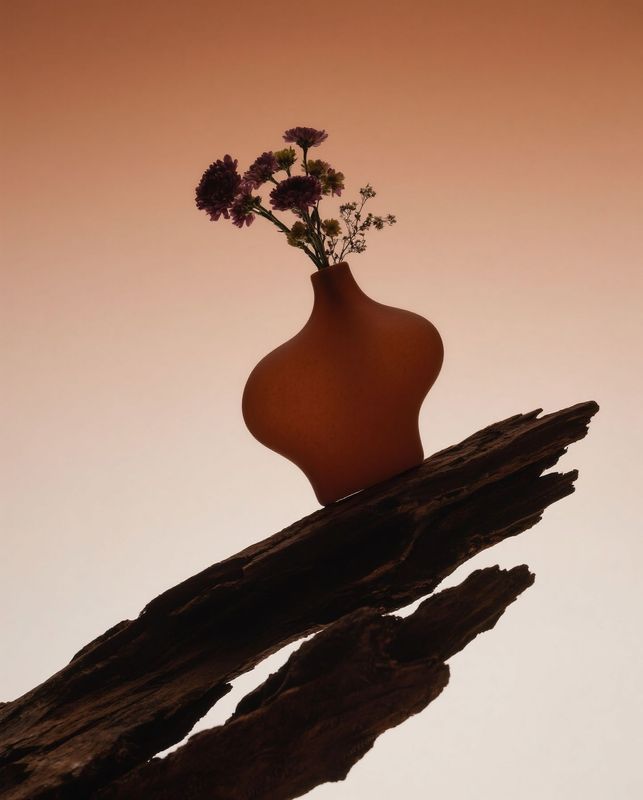 a vase with flowers sitting on a branch