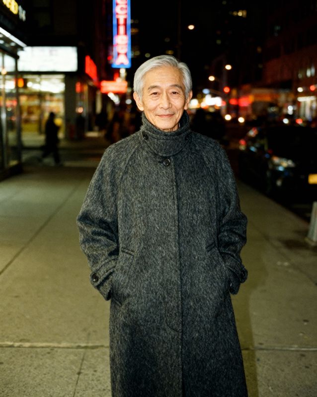 a man standing on a sidewalk at night