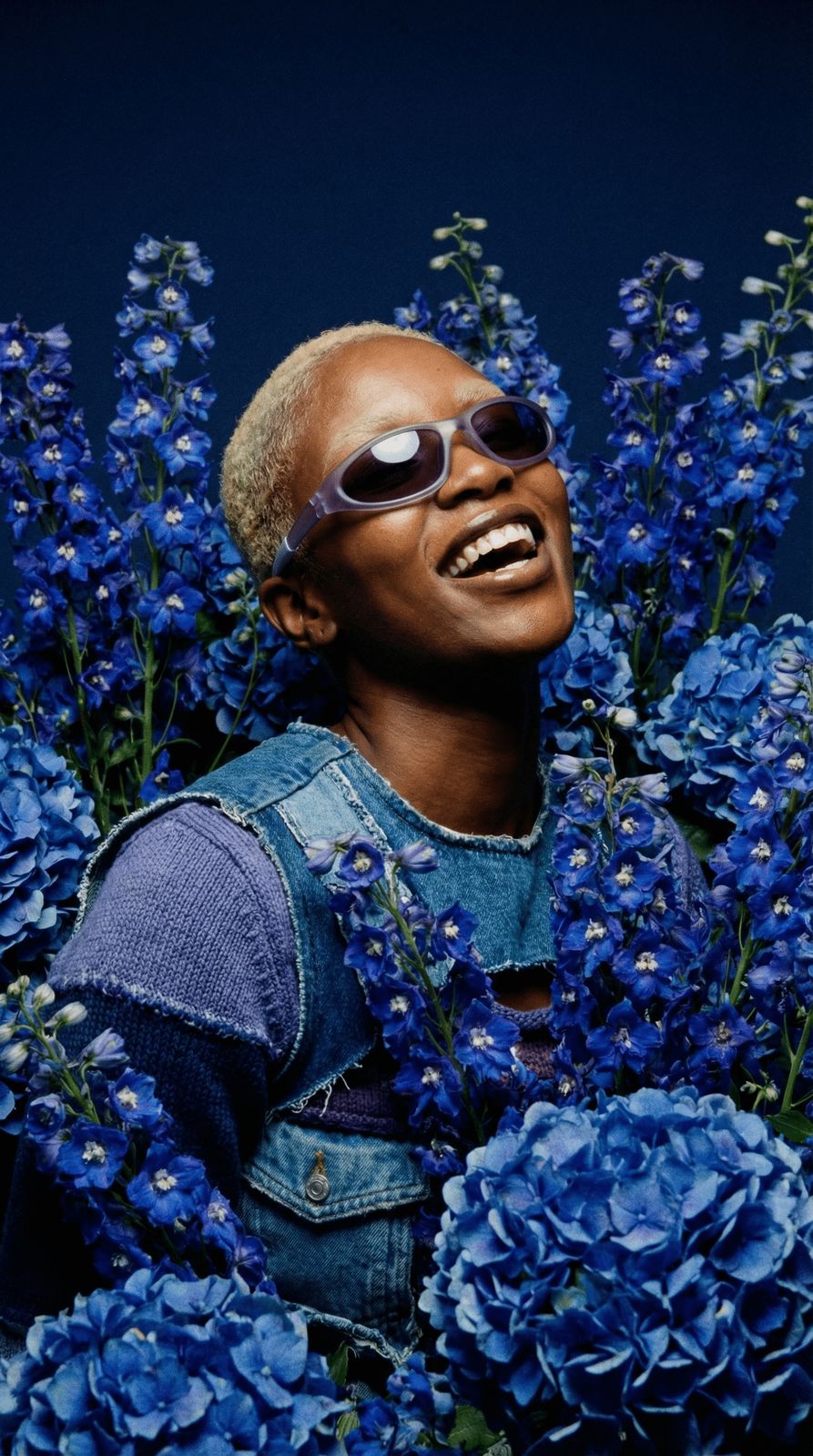 a black man with sunglasses and blue flowers