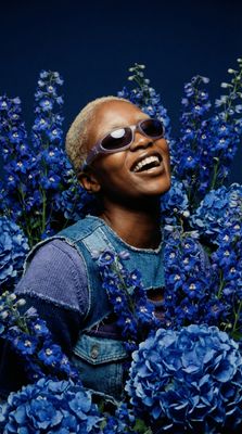 a black man with sunglasses and blue flowers